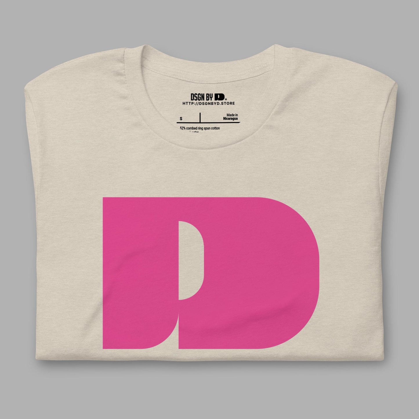 A folded beige cotton unisex graphic tee with letter D .