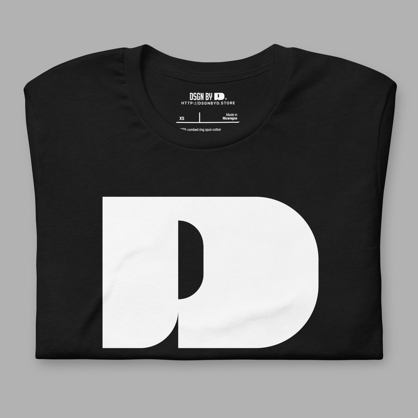 A folded black cotton unisex graphic tee with letter D .