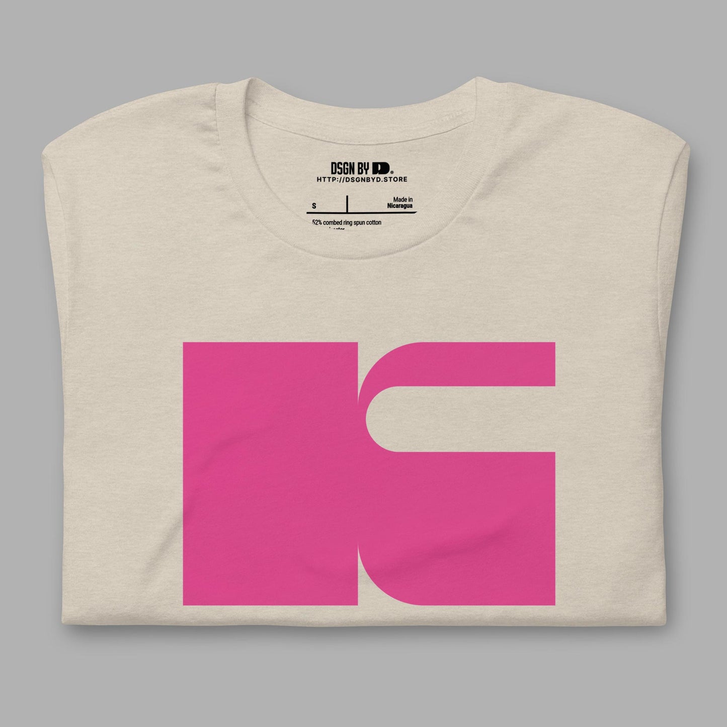 A folded beige cotton unisex graphic tee with letter K.
