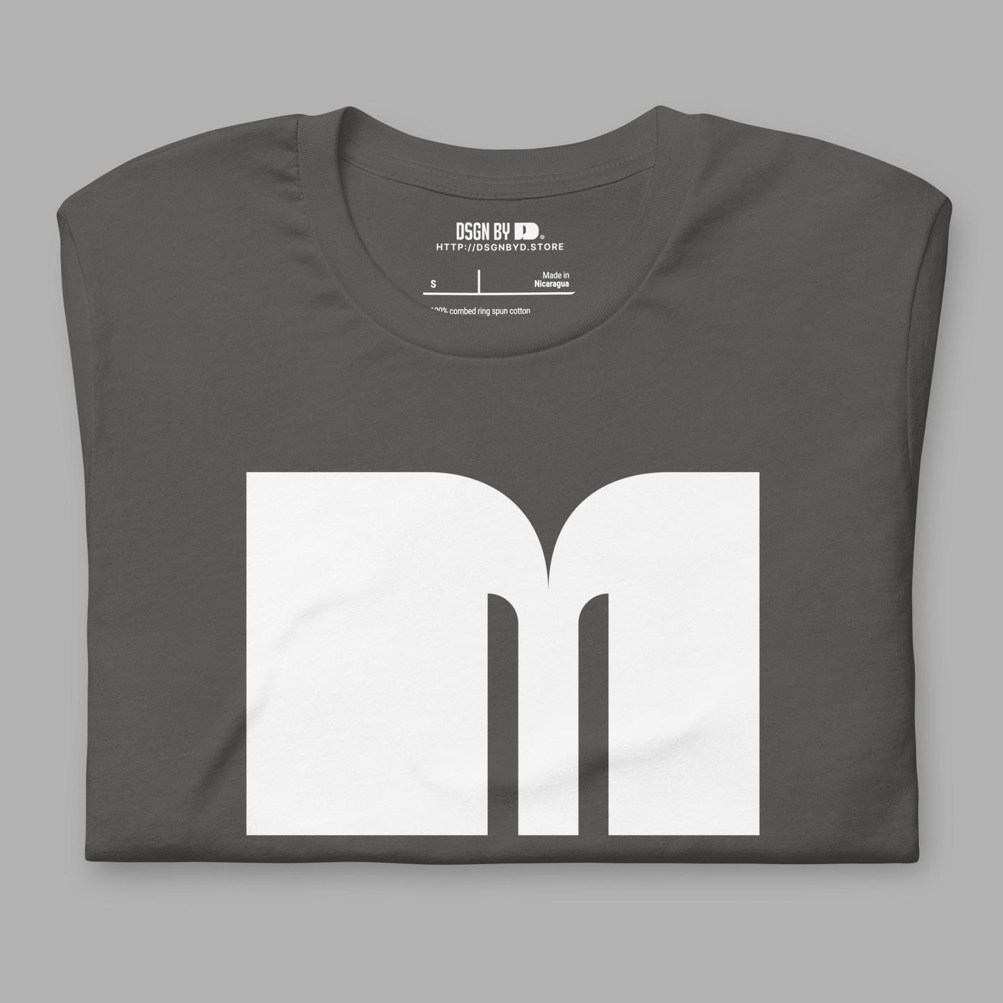 A folded grey cotton unisex graphic tee with letter M.