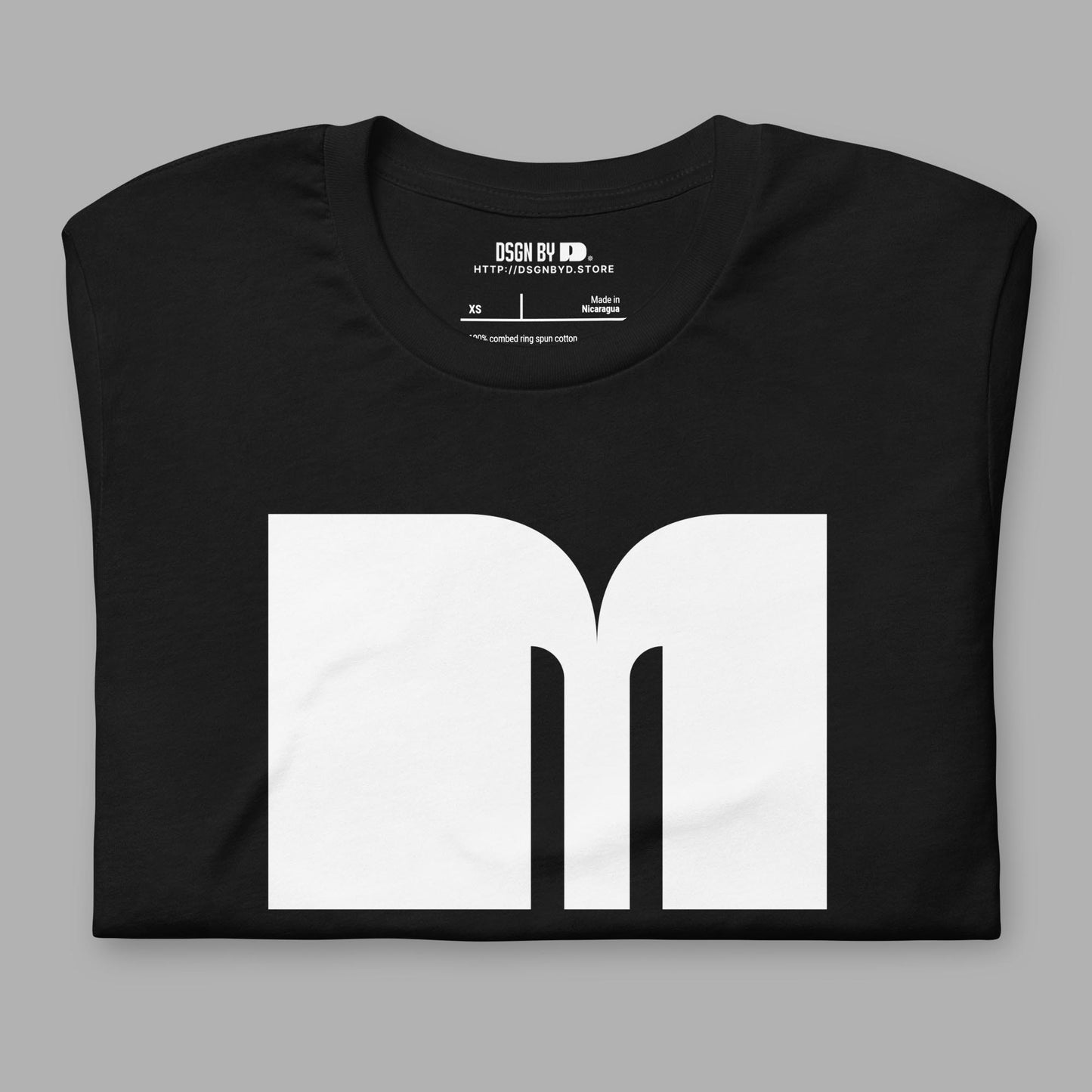 A folded black cotton unisex graphic tee with letter M.