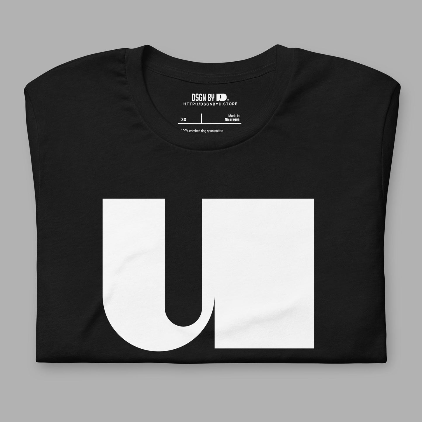 A folded black cotton unisex graphic tee with letter U.